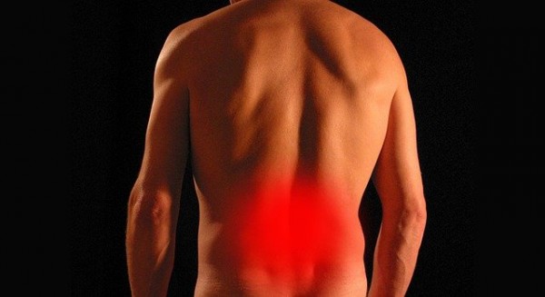 An image of the back of a male with a red pain spot in his lower back to represent sciatic to discuss types of sciatic nerve pain.