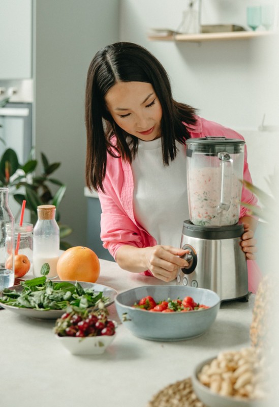 An image of a person preparing a salad and blending up a smoothie to talk about how nutrition and chronic disease are connected. 
