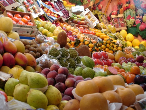 An image of boxes of fruits piled high at a supermarket to discuss how what you eat matters because there is a relationship between food and pain. 