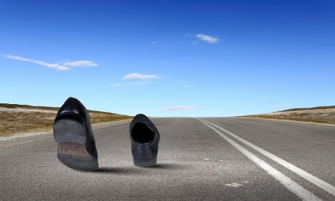 An image of shoes walking down the road without a person in them to talk about the invisibility of the chronic pain crisis due to the focus on the opioid crisis.