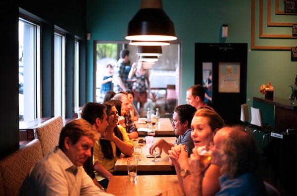 An image of a bunch of family sitting at a table at a restaurant to discuss chronic illness and relationships. 