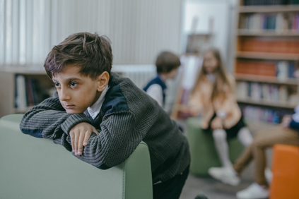 A boy sitting alone feeling bad.